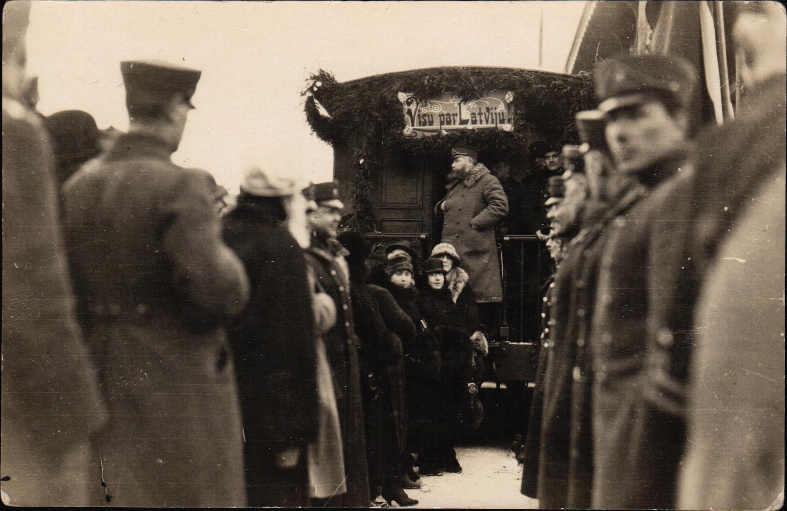 Latvijas Bruņoto spēku pulkvedis Krišs Ķūķis atstāj Liepāju. Fonā redzams vilciena vagons, uz kura ir uzraksts: "Visu par Latviju". 1924.g.